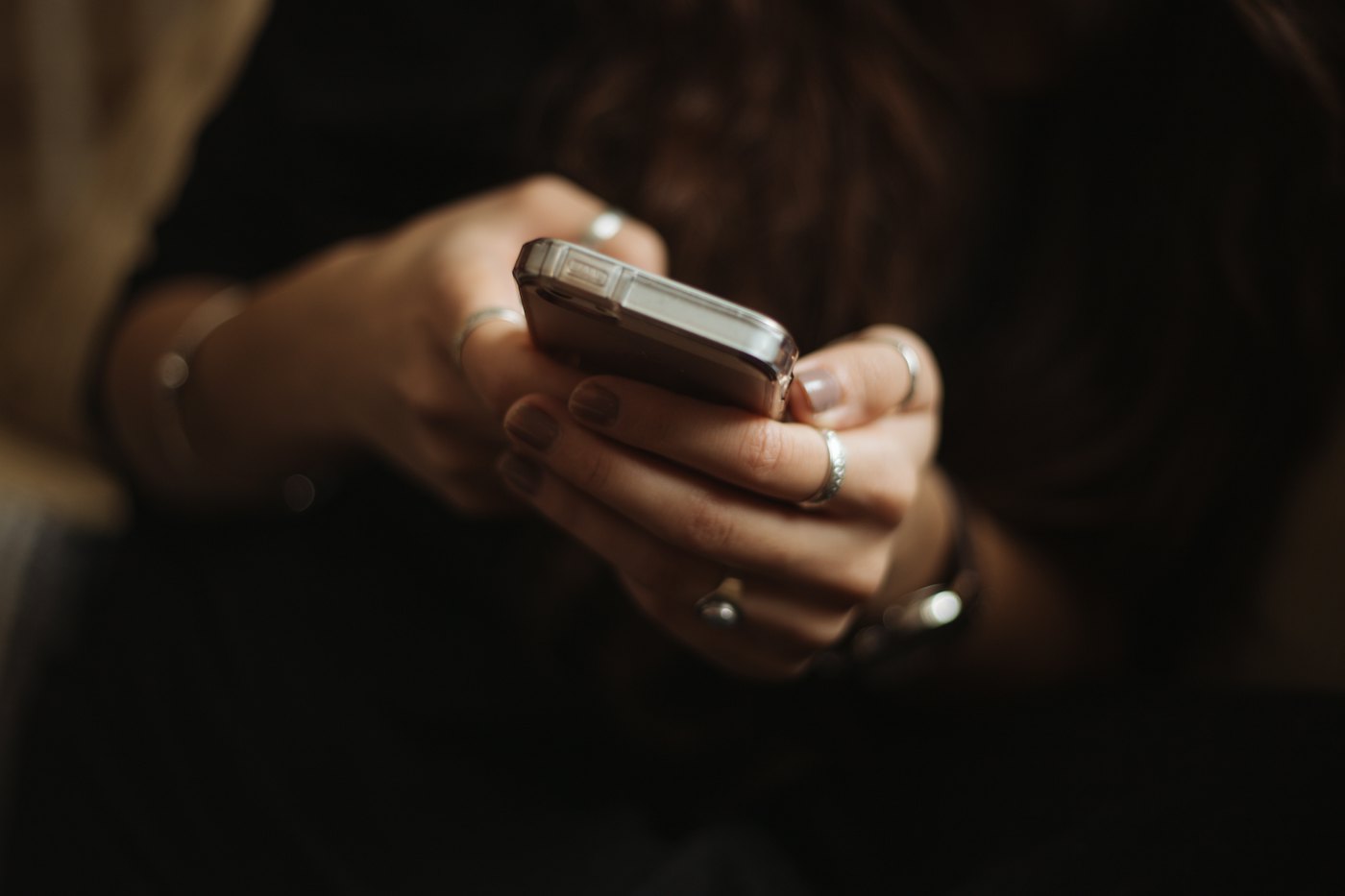 Mãos segurando um celular à noite